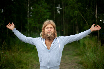 Guy with thick unshaved beard. Young man in white hoodie. Man in nature.