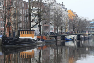 Amsterdam Zwanenburgwal Canal View with Bridge, Boats, House Facades and Winter Trees, Netherlands