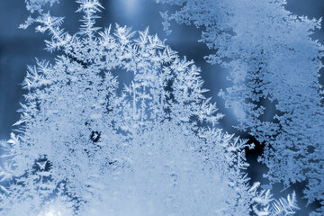 frosty patterns on the window glass closeup. natural textures and backgrounds. ice patterns on...