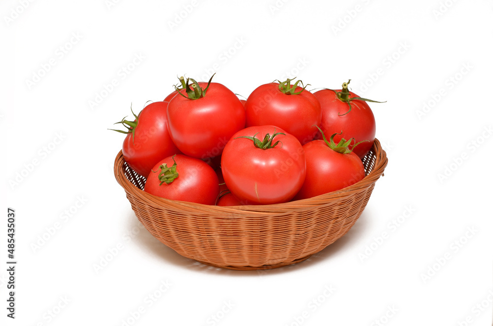 Wall mural fresh tomatoes in a basket isolated on white background