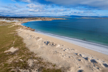 Beautiful Gurteen bay beach and blue color ocean water, cloudy sky. Stunning Irish nature scene in county Galway, Ireland. Warm sunny day. Popular travel area with stunning scenery