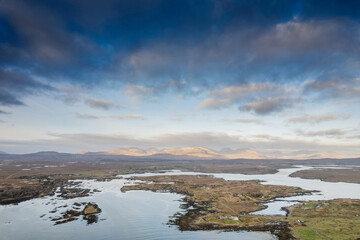 Aerial view on stunning Connemara nature scenery and Atlantic ocean from Roundstone town area, county Galway, Ireland. Ocean surface and mountains in the background. Irish landscape