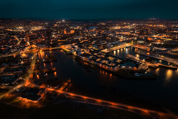 Galway city illuminated at night, port area. Aerial high point view. Dark scene. Town at night....