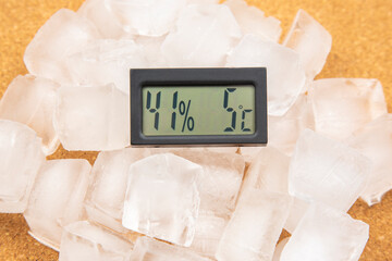 digital thermometer for measuring air temperature and humidity against the background of frozen ice