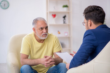 Old man visiting young male psychotherapist