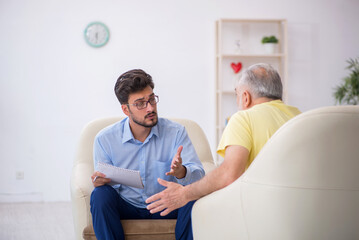 Old man visiting young male psychotherapist