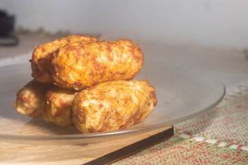 Rice patties or fritters made of cooked rice, carrot, onion, garlic, celery stalks,Brazilian rice cakes,copy space and natural anbiente.