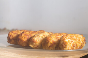 Rice patties or fritters made of cooked rice, carrot, onion, garlic, celery stalks,Brazilian rice cakes,copy space and natural anbiente.