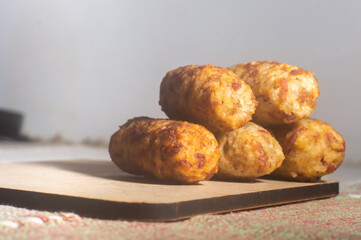 Rice patties or fritters made of cooked rice, carrot, onion, garlic, celery stalks,Brazilian rice cakes,copy space and natural anbiente.
