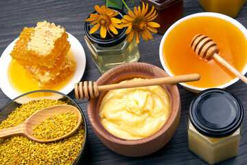 Fresh flower honey of different varieties, pollen and honeycomb with spoons on a wooden background. Organic Vitamin Health Food