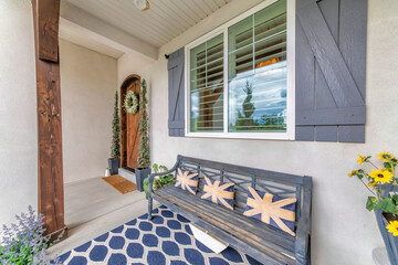 Decorated front porch with bench, flowers and carpet