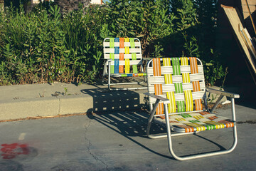 Colorful retro lawn chairs on concrete during summer