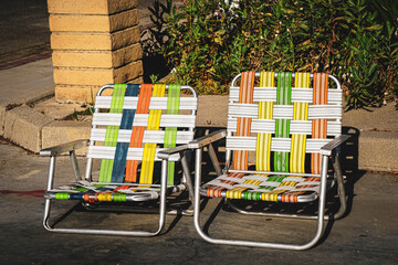 Colorful retro lawn chairs on concrete during summer