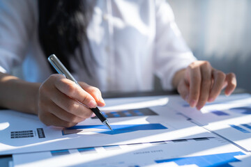 Businesswoman using document paper calculator and laptop analysis graph report company financial budget report investment and cost work progress and planning for future in the office room.