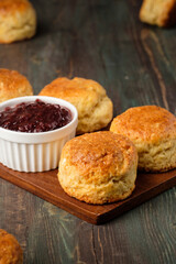 group of scones on wood plate with jam on table