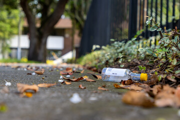 Small liquor bottle on sidewalk