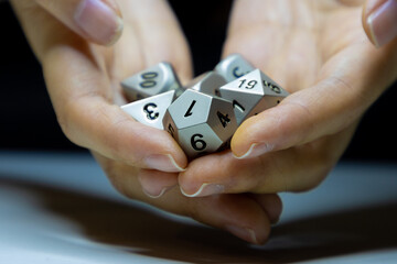 Female hands holding metal fantasy game dice