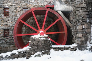 Red water wheel on old mill