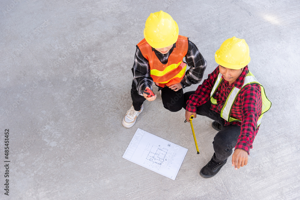 Poster architect and client discuss help create plan with blueprint of the building at construction site fl
