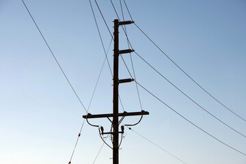 Electricity distribution pylon and power lines under blue sky