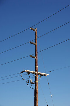 Electricity distribution pylon and power lines under blue sky