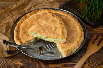 Closed cabbage pie made with yeast dough on a metal baking sheet. Traditional Russian cuisine.