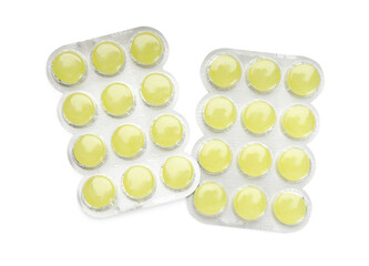 Blisters with yellow cough drops on white background, top view