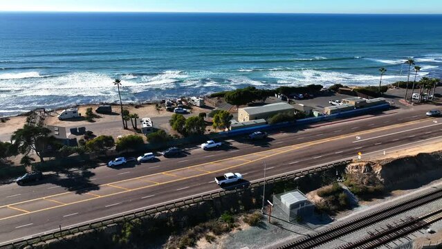 Aerial view, empty Railway lines, traffic highway near Cardiff By The Sea. Drone flyover, blue ocean, train lines.