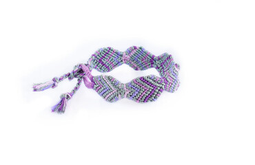 Tied DIY friendship bracelet with unusual braiding pattern on white background