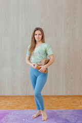 Young caucasian woman doing yoga asanas with yoga bricks at home.