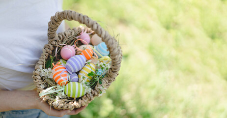 Easter egg hunt in spring garden. Funny teen girl with eggs basket and bunny ears on Easter egg hunt in sunny spring garden. Celebrating Easter. Happy easter card