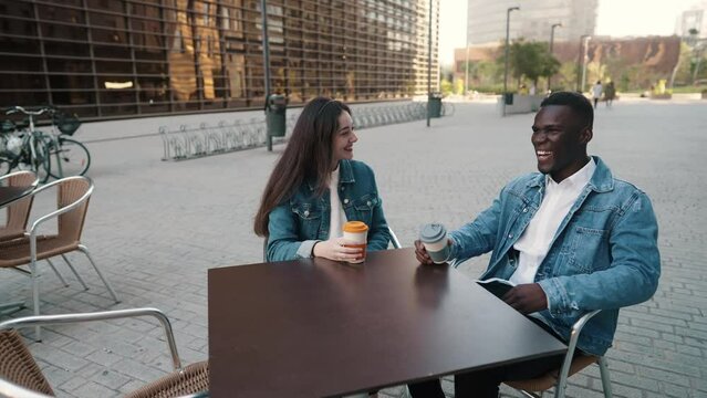 Cheerful diverse friends drinking coffee in city