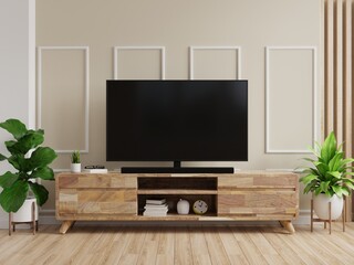 TV on cabinet with cream color wall and wood flooring.