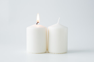 Fototapeta na wymiar Two candles on a light background