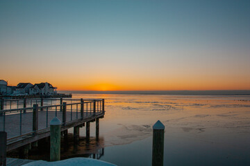 Fototapeta na wymiar Sunrise over the water by the dock