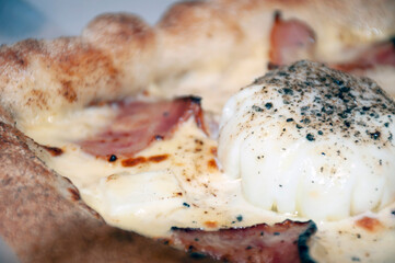 close-up of khachapuri consisting of mozzarella, maasdam, feta, bacon, poached egg.