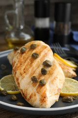 Delicious chicken fillets with capers and lemon on plate, closeup