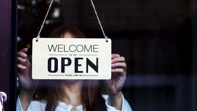 the cafe or store closed for christmas holidays. a woman turn closed open sign on glass door at entrance. Realtime Video 4k