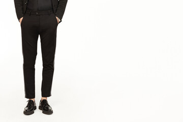 Young man in elegant suit, black shoes standing isolated on white background