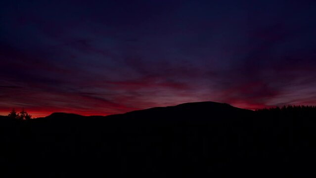 Pink and purple sky sunset timelapse over the mountains.