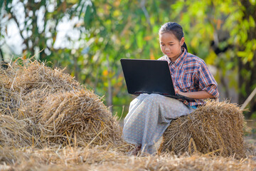 Naklejka na ściany i meble Asian girls living in rural areas and schools in rural Thailand are happy to sit and watch laptops for education and study online using their laptops.