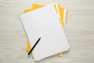 Yellow files with blank sheets of paper and pen on white wooden table, top view. Space for design - Powered by Adobe