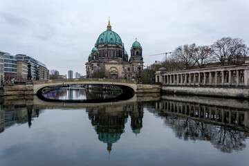 Fototapeta na wymiar View of the Berliner Dom (Berlin Cathedral), a monumental German Evangelical church and dynastic tomb (House of Hohenzollern) on the Museum Island in central Berlin from the bank of the River Spree