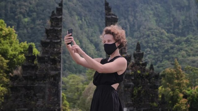 Lifestyle girl blogger in all black shooting on Traditional Balinese Hindu gate Candi Bentar, Bedugul, Indonesia