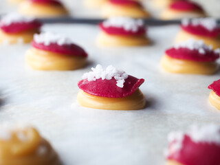 small choux pastry dough with red sugar crust and white sugar pearl