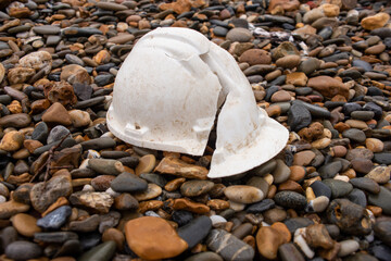 broken hardhat lying on stones