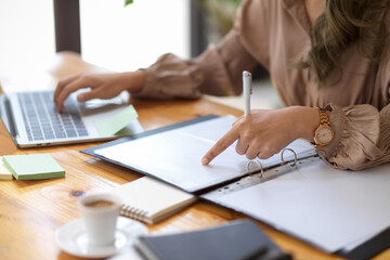 Cropped image, A female employee pointing finger on documents.
