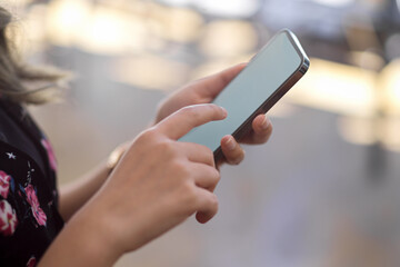 Side view, A female using smartphone with blurred background.