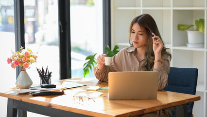 Female marketing manager drinking coffee shot while working on her project