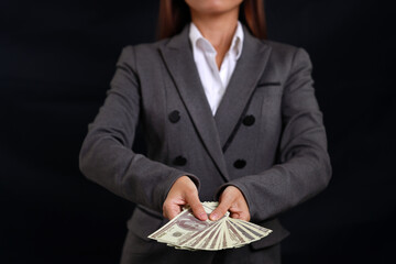 Attractive professional female hands standing and showing bank note for advertising on black background isolated